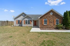 Richlands house for rent - A house with a grey roof and brown brick wall with a white door and windows.