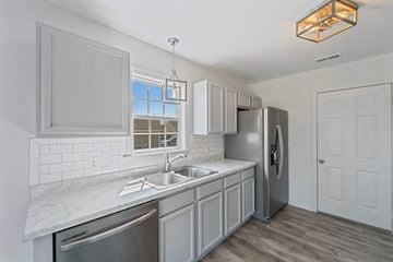 Richlands house for rent - A modern kitchen with a stainless steel refrigerator and a marble countertop.