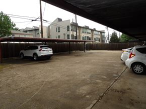 Dallas apartment for rent - A white car is parked in a driveway under a covered area.