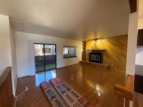 Boulder apartment for rent - A room with a fireplace and wooden floors.