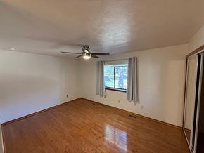 Boulder apartment for rent - A room with a ceiling fan and a window with curtains.
