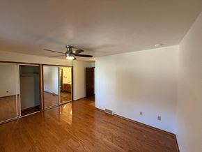 Boulder apartment for rent - A room with a ceiling fan and wooden floors.