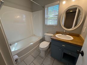 Charlotte house for rent - A bathroom with a white tub, toilet, and sink.