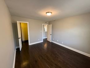 Charlotte house for rent - A room with wooden floors and white walls.