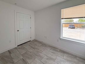 San Antonio apartment for rent - A room with a white door and a window showing a parking lot outside.