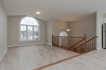 Kingston apartment for rent - A room with a large arched window and wooden flooring.