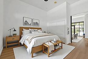 Moorpark apartment for rent - A bedroom with a large bed and a nightstand with a plant on it.