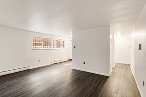 Denver apartment for rent - A room with wooden floors and white walls.