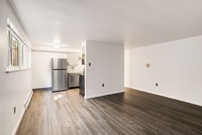 Denver apartment for rent - A kitchen area with a refrigerator, trash can, and a sink.
