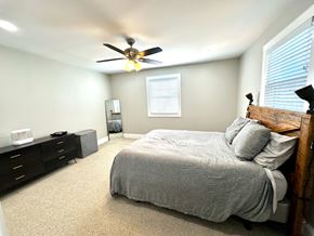 Greenville house for rent - A bedroom with a bed, dresser, and ceiling fan.