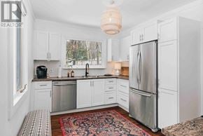 Lake Of Bays (Sinclair) house for rent - A bedroom with a white bed and a wooden headboard.