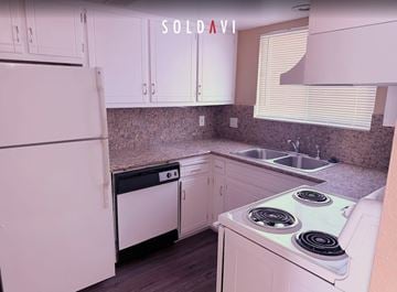 Merced house for rent - A kitchen with white appliances and cabinets is for sale.