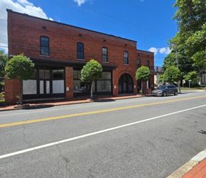Halifax apartment for rent - A red brick building with a black awning sits on the corner of a street.