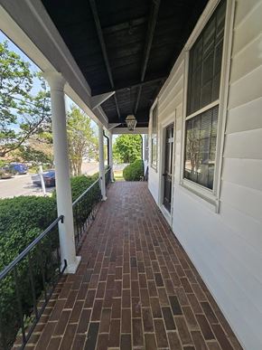 Warrenton apartment for rent - A long brick walkway leads to a white building.