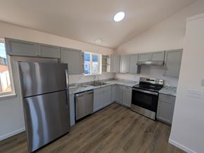 Woodland Park apartment for rent - A kitchen with a stainless steel refrigerator and wooden flooring.