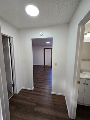 Woodland Park apartment for rent - A hallway with a light on the ceiling and a door on the left.