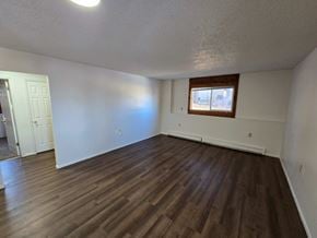Woodland Park apartment for rent - A room with wooden flooring and a window.