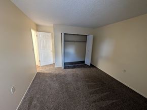Woodland Park apartment for rent - A room with a brown carpet and a white door and a white wall.
