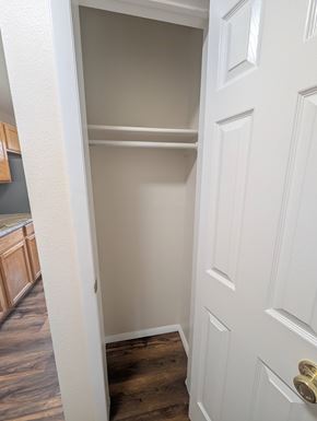 Woodland Park apartment for rent - A white door with a gold handle is open to a small closet.