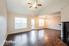 Clarksville house for rent - A spacious room with wood flooring and a ceiling fan.