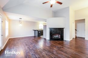 Clarksville house for rent - A spacious living room with a fireplace and wooden floors.