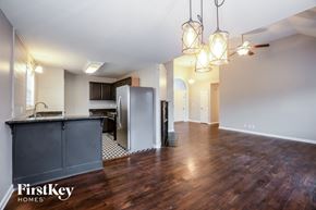 Clarksville house for rent - A kitchen area with wooden floors and a refrigerator.