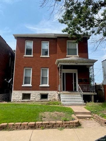 St. Louis house for rent - A red brick house with a white door and windows.