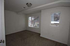 Whitefish apartment for rent - A room with a carpeted floor and two windows with blinds.