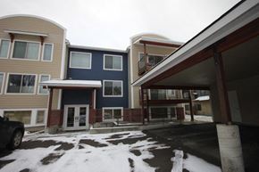 Whitefish apartment for rent - A parking lot in front of a building with a car parked.