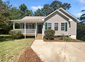 Winston-Salem house for rent - A small house with a porch and green shutters.