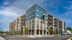 Huntsville apartment for rent - A modern apartment building with a mix of blue and beige balconies.