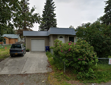 Anchorage house for rent - A house with a garage and a car parked in front.