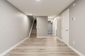 Spruce Grove apartment for rent - A long hallway with a staircase on the left side.