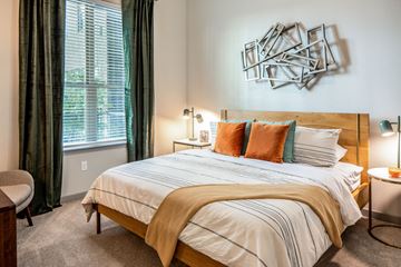 Houston apartment for rent - A bedroom with a large bed and a chair.
