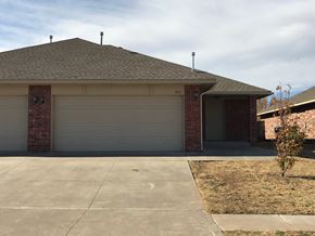 Yukon apartment for rent - A house with a garage door and a driveway.