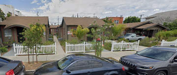 Huntington Park apartment for rent - A car is parked in front of a house with a white picket fence.