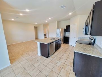 Killeen house for rent - A kitchen with a refrigerator, microwave, and oven.