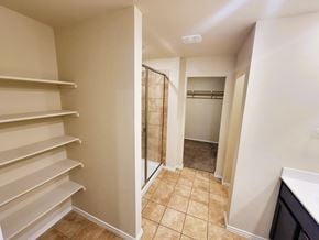 Killeen house for rent - A walk-in closet with shelves and a mirrored door.