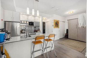 Ottawa apartment for rent - A kitchen with a stainless steel refrigerator and a microwave above the stove.