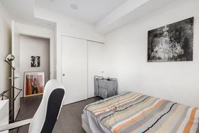 Ottawa apartment for rent - A bedroom with a bed, chair, and painting on the wall.