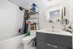 Ottawa apartment for rent - A white toilet sits next to a sink in a small bathroom.