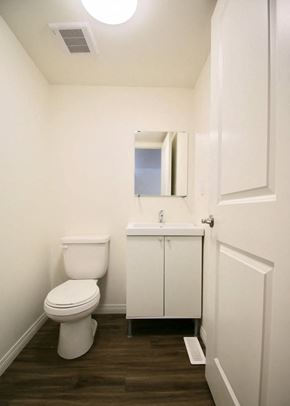 Edmonton apartment for rent - A white toilet sits next to a sink in a small bathroom.