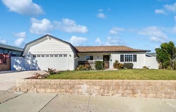 Ventura house for rent - A white house with a brown roof and a garage door.