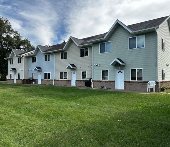 Menomonie apartment for rent - A row of houses with green lawns in front.