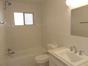 Dallas apartment for rent - A white bathroom with a toilet, sink, and bathtub.