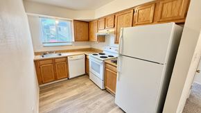 Wheat Ridge apartment for rent - A parking lot with cars and a building in the background.