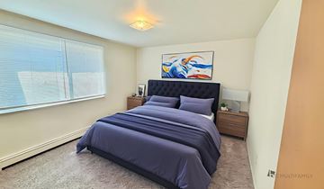 Wheat Ridge apartment for rent - A bedroom with a large bed and a painting on the wall.