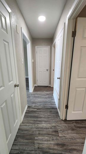 Copperas Cove apartment for rent - A long hallway with white doors and a wooden floor.
