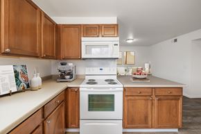 Denver apartment for rent - A kitchen with a white stove top oven and a white microwave above it.