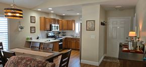 Sarasota house for rent - A kitchen with a table and chairs in the foreground and a counter top with a plant on it.